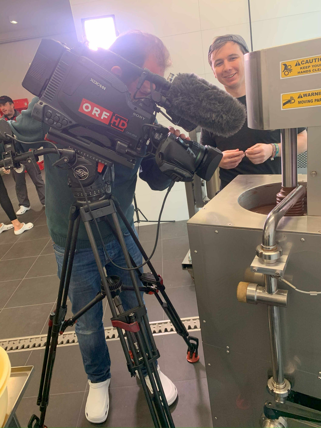 ORF Kameramann filmt die Schokoladenpresse in der Genussfux Manufaktur während der Produktion