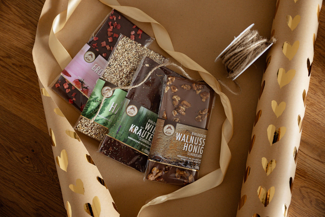 Genussfux-Schokolade wird in Geschenkspapier  verpakct und mit Geschenksbändern geschmückt