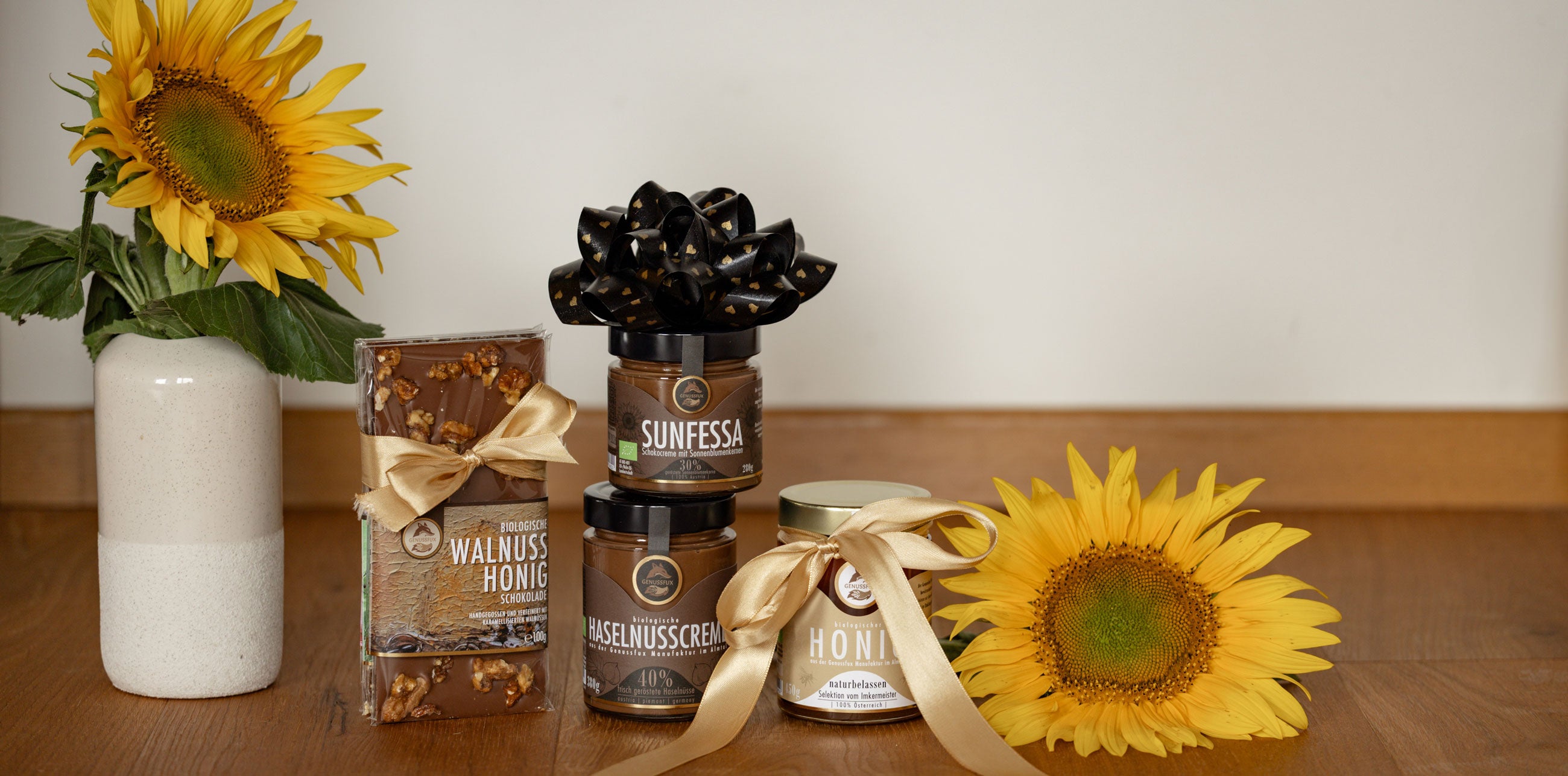 Genussfux Leckereien als Geschenk mit Schleifen verpackt und mit Sonnenblumen dekoriert