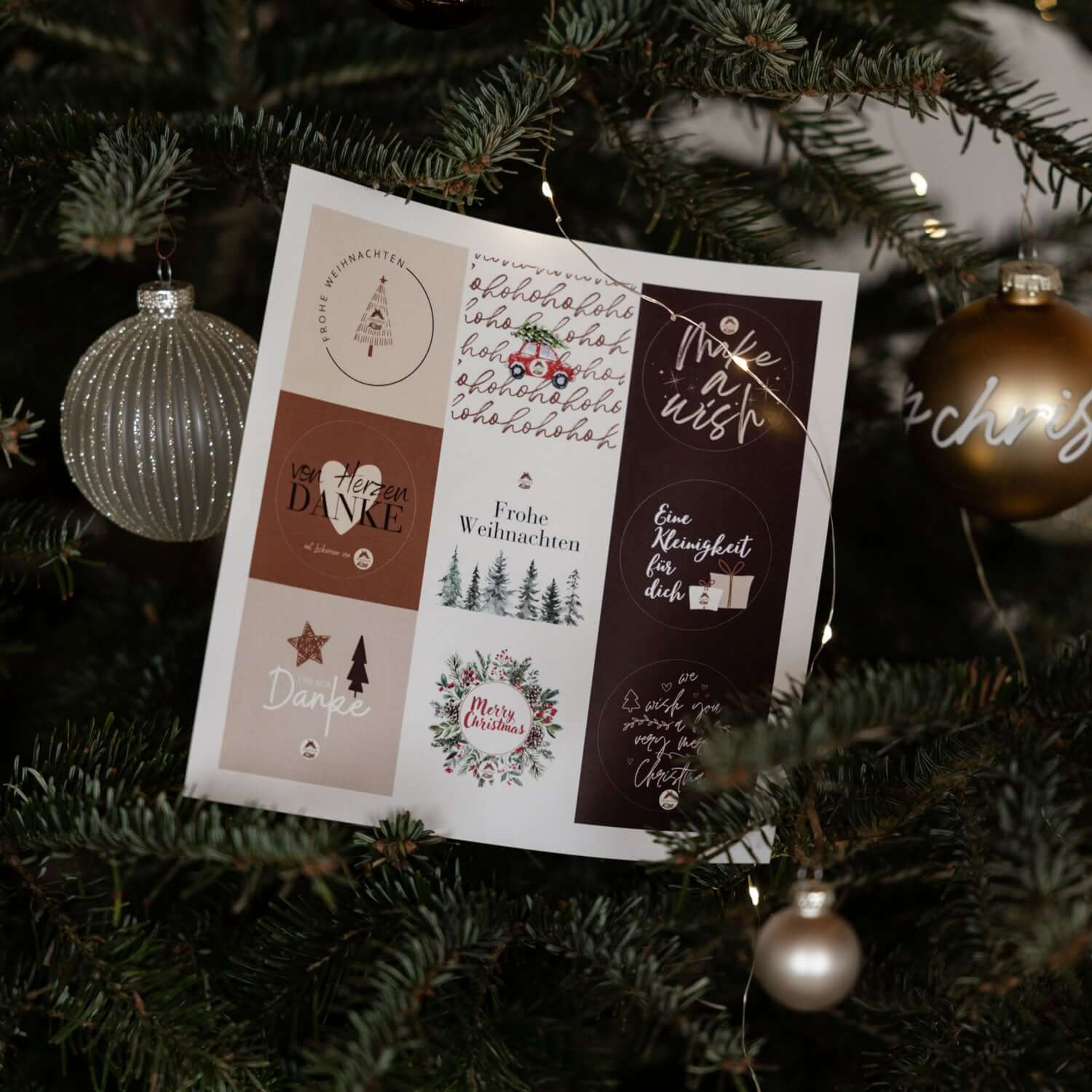Genussfux Weihnachts-Stickerbogen mit neun runden Motiven (u. a. Frohe Weihnachten, Merry Christmas, Von Herzen Danke, Make a Wish) an einem Tannenbaumzweig